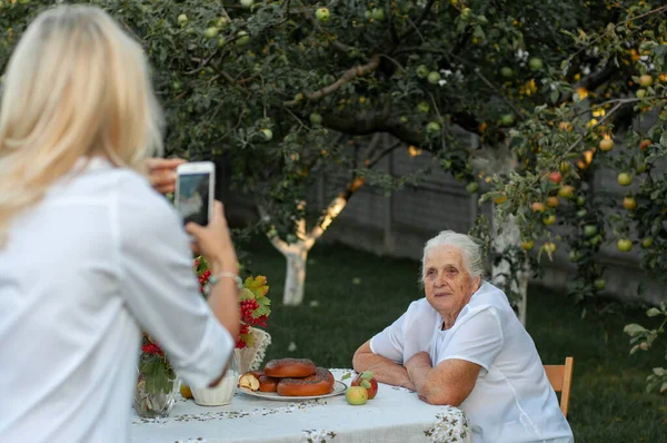 Langhaarige Blondine Fotografiert Ihre Großmutter Telefon lizenzfreie Stockbilder