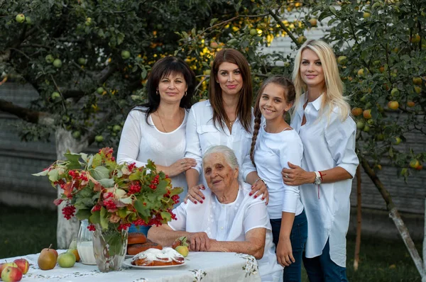 Babcia Siedzi Przy Stole Ogrodzie Podczas Gdy Jej Córka Trzy Zdjęcie Stockowe