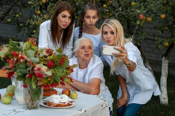 Neunzigjährige Großmutter Und Ihre Schönen Enkelinnen Scherzen Und Machen Gesichter Stockbild