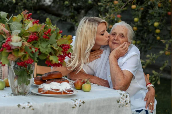 Bela Loira Beija Sua Querida Avó Bochecha Contra Pano Fundo Imagem De Stock