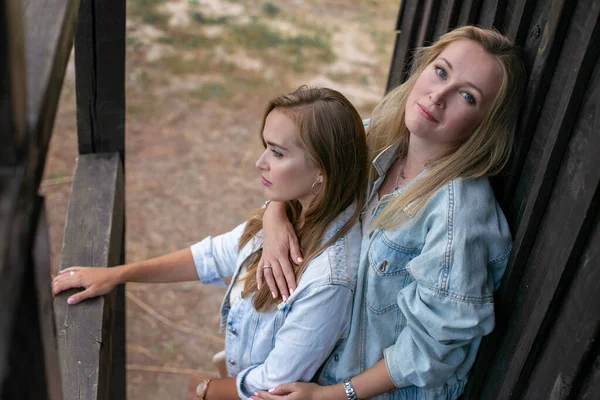 Two Beautiful Young Women Stand Embracing Background Old Rural Building — Stock Photo, Image