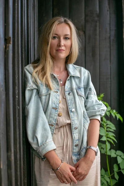 Mooie Blonde Jonge Vrouw Staat Achtergrond Van Een Oud Houten — Stockfoto