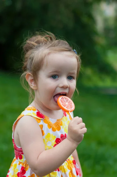 Cute Baby Bright Summer Dress Eats Candy Stick Pleasure — Stock Photo, Image