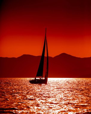 Gün batımında açık denizde yat silueti