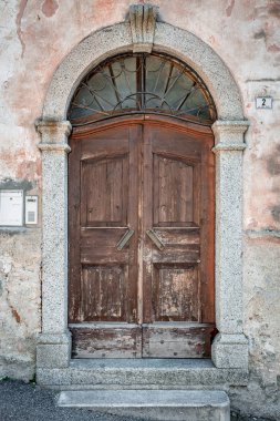 Ahşap gri eski kemer kapılı paslı demir kafes, evin gri alçı duvarlı