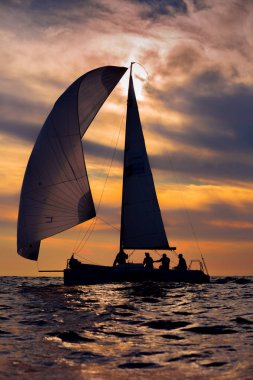 Gün batımında açık denizde yat silueti
