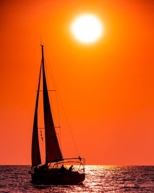 Gün batımında açık denizde yat silueti
