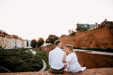 Varşova 'nın eski kasabası Stare Miasto' da tuğla köprüde oturan genç ve güzel kadın ve adam. 
