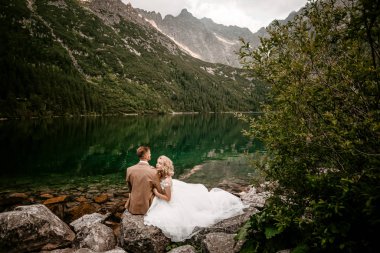 Polonya 'nın güneyindeki Tatra Dağları' nda Morskie Oko Gölü 'nde poz veren harika genç bir çift gelin ve damat.