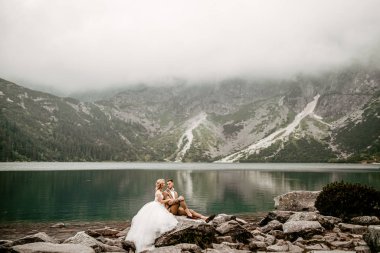 Polonya 'nın güneyindeki Tatra Dağları' ndaki Morskie Oko gölünde güzel gelin ve damat.