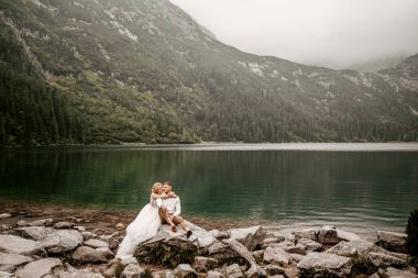 Polonya 'nın güneyindeki Tatra Dağları' ndaki Morskie Oko gölünde güzel gelin ve damat.