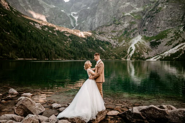 Polonya 'nın güneyindeki Tatra Dağları' nda Morskie Oko gölünde poz veren iki genç gelin ve damat.