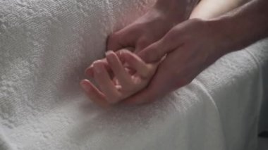 Avuç içi masajı. Masör genç bir kızın avucuna masaj yapıyor.