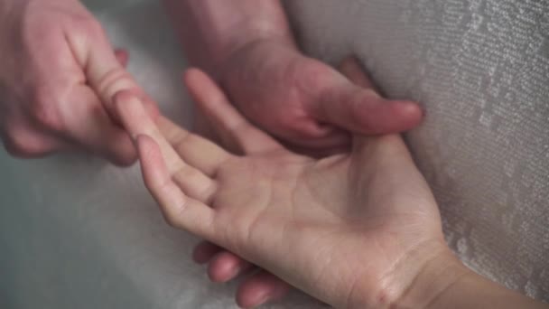A massagem na palma da mão. massagista fazendo massagem na palma da mão de uma jovem . — Vídeo de Stock