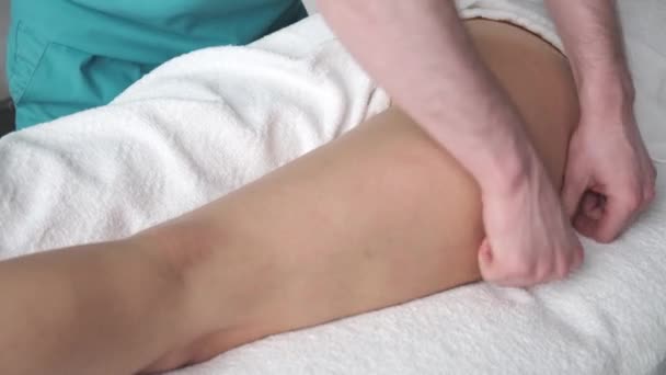 Anti-cellulite massage Masseur doing massage young girl  his feet excess weight — Stock Video