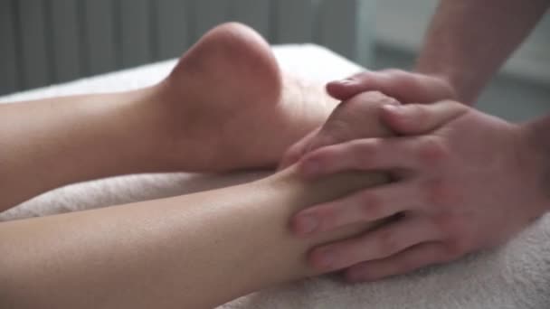 Массаж ног очень близко. массажист мужского пола массирует ноги девушкам — стоковое видео