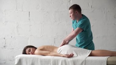 Sırt masajı yakın plan. Erkek masör masaj yapıyor. Skolyoz genç esmer kız.