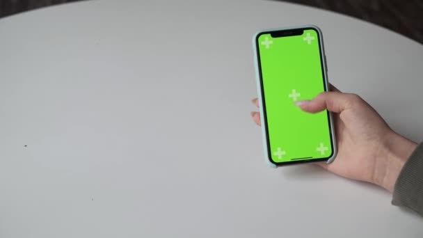 Mobiltelefon med grön skärm på nära håll. Chroma nyckel på mobilen. — Stockvideo