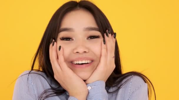 Asian Girl on a yellow background. emotions of joy and surprise. Face closeup — Stock Video