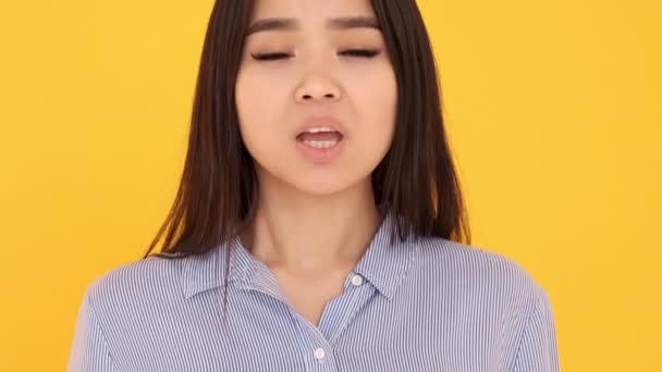 Flicka på en gul bakgrund skriker nej. kvinna asiatisk flicka förnekar missnöje — Stockvideo
