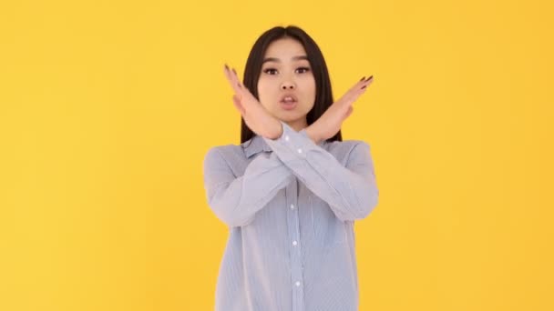 Girl on a yellow background screams no. woman Asian girl denies dissatisfaction — Stock Video