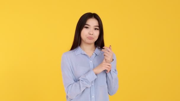 Young pensive girl thinks on your toes Asian woman on yellow background — Stock Video