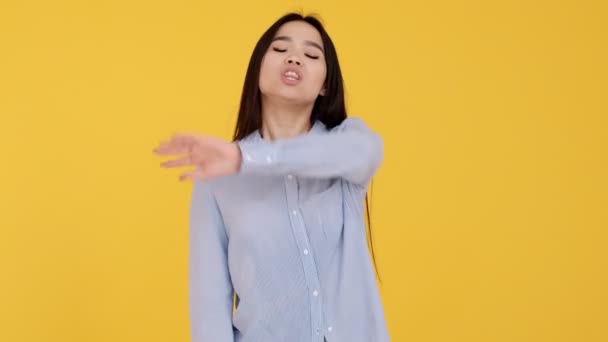 Menina asiática em um fundo amarelo. não consentimento e negação. mulher gritando não — Vídeo de Stock