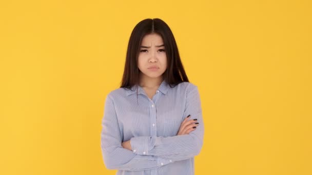 Chica asiática fondo amarillo. emociones de descontento. una mujer de mal humor , — Vídeos de Stock