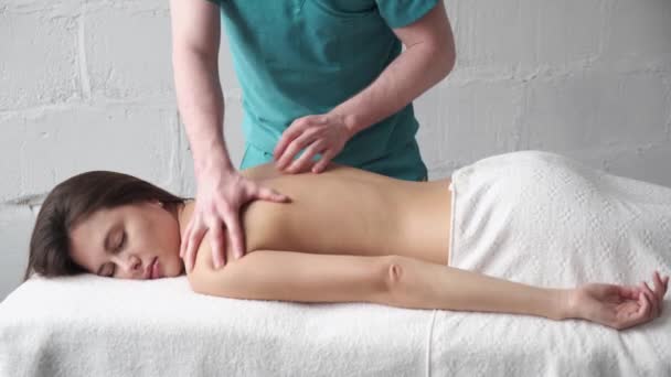 Massagem nas costas close up. massagista masculino fazendo massagem escoliose jovem escuro menina — Vídeo de Stock