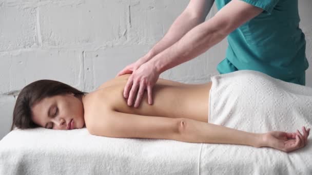 Primer plano del masaje de espalda. Masajista masculino haciendo masaje escoliosis joven chica oscura — Vídeos de Stock