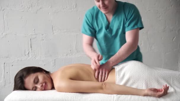 Masaż pleców zbliżenie. mężczyzna masażysta robi masaż skolioza młody ciemny dziewczyna — Wideo stockowe