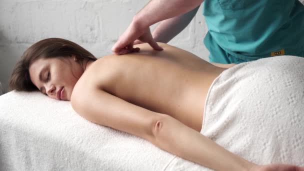 Massagem nas costas close up. massagista masculino fazendo massagem escoliose jovem escuro menina — Vídeo de Stock