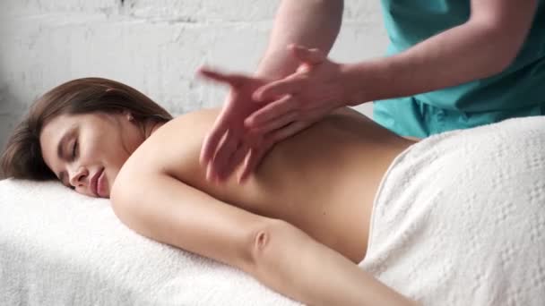 Detailní masáž zad. Muž masér dělá masáž scoliosis mladý tmavý dívka — Stock video