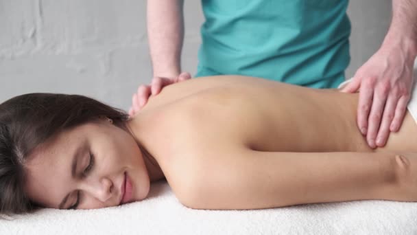 Närbild av ryggmassage. Manlig massör gör massage skolios ung mörk flicka — Stockvideo