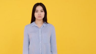 Genç Asyalı sarı arka plan kızı şans diliyor. pozitif sonuç bekleniyor