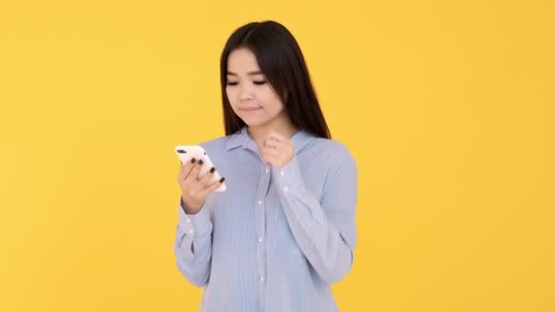 Menina em um fundo amarelo. mostra as mãos em um espaço vazio. espaço de cópia — Vídeo de Stock