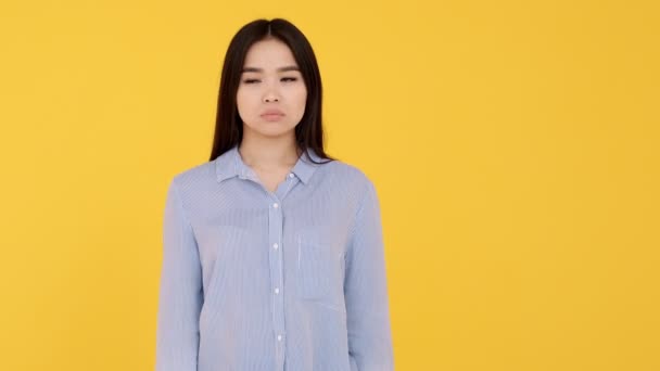 Junges Mädchen asiatischen gelben Hintergrund drückt ihm die Daumen. Positives Ergebnis abwarten — Stockvideo