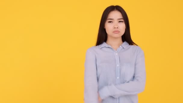 Девушка азиатка на жёлтом фоне. вдумчивый человек и блестящая идея — стоковое видео