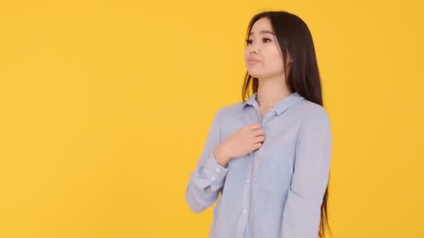 Asian girl on yellow background . the woman is hot. waving hands from the heat — Stock Video