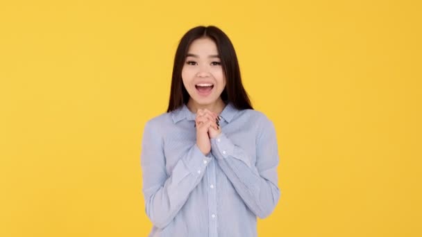 Chica joven disfruta sobre un fondo amarillo. mujer emoción de deleite — Vídeos de Stock