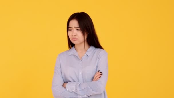 Pensive Asian girl on yellow background, idea concept — Stock Video