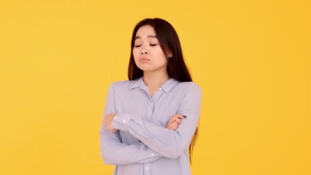 Förolämpade asiatiska unga flicka på gul bakgrund. kopieringsutrymme — Stockvideo