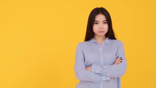 노란 배경의 젊은 아시아 소녀. 동의하지 않는 불만의 감정 — 비디오