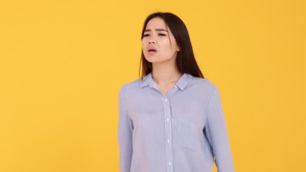 Het meisje zwaait met haar handen voor de camera. Joy ontmoeting. vrouw op gele achtergrond — Stockvideo