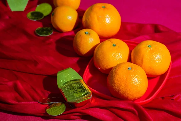 Oranges and gold on red fabric , Chinese New Year — Stock Photo, Image