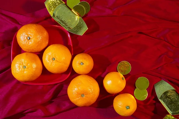 Oranges and gold on red fabric , Chinese New Year — Stock Photo, Image