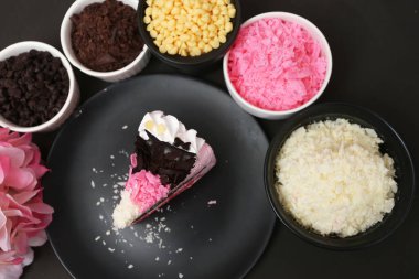 Siyah arka planda çilekli süt keki