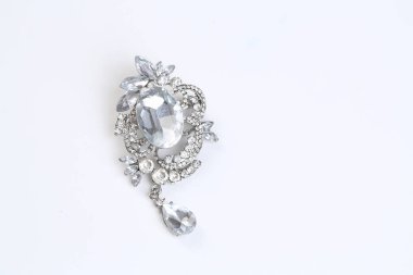 Gümüş çiçekli ve mücevherli bir broş.