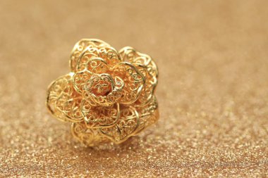 Işıltılı arka planda altın gül yüzüğü