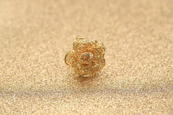 gold rose flower ring on glitter background